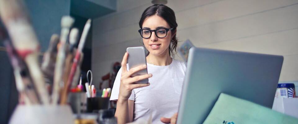 Profissional trabalhando com computador e smartphone em escritório