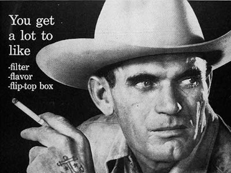 Propaganda antiga da Marlboro. Há um caubói fumando um cigarro e o texto: “you get a lot to like: filter, flavor, flip-top box”. 