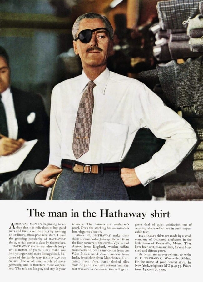 Propaganda antiga da Hathaway. Um homem de camisa social, terno e um tapa olho. O texto diz “The man in the Hathaway shirt”.