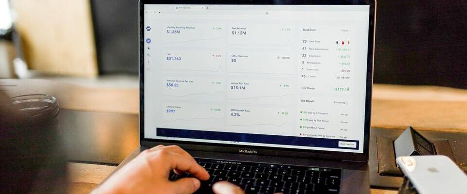 Lista com números de faturamento na tela de um MacBook Pro cinza escuro.