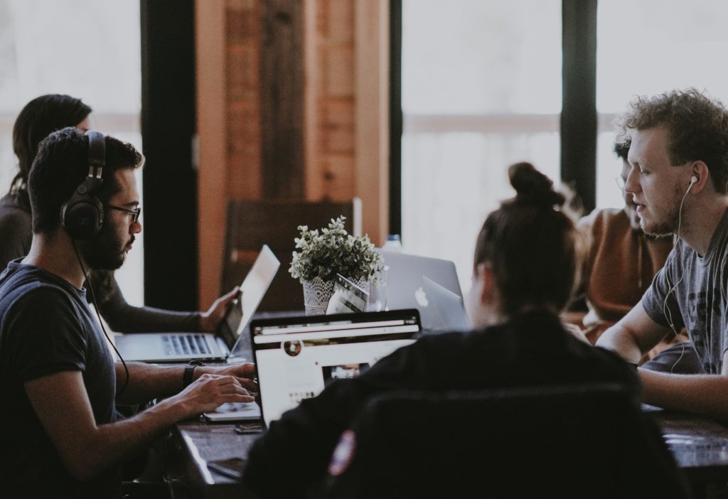 Equipe de gestão de marketing trabalhando em volta de uma mesa.