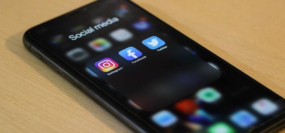 Tela inicial de iPhone com ícones para Instagram, Facebook e Twitter.