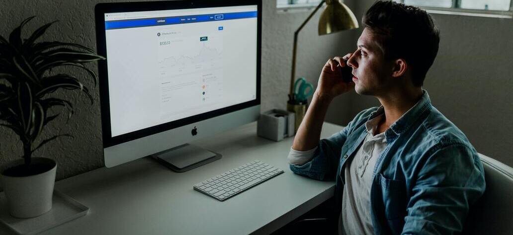 Homem sentado em frente ao computador fazendo pesquisa de palavras-chave para sites.