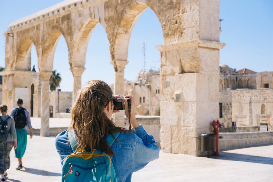 Turista fotografando ruínas durante uma viagem.